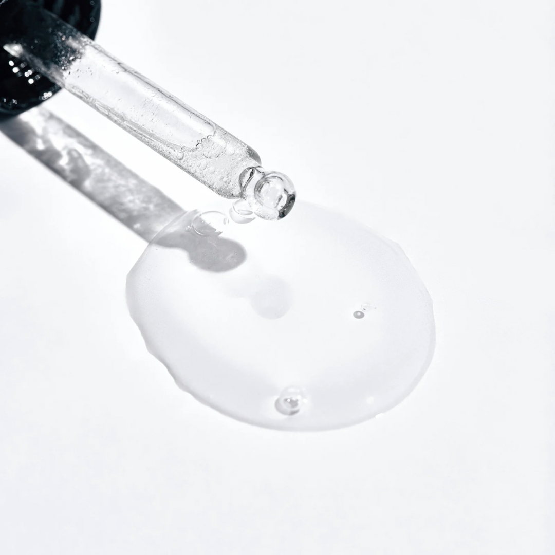 Eine Nahaufnahme eines Flüssigkeitstropfens, der aus einer Pipette kommt.