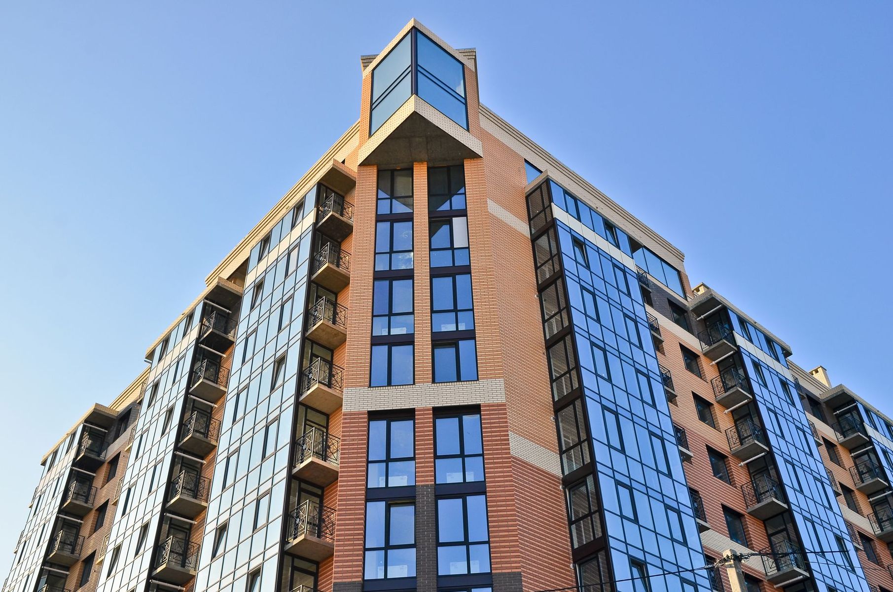 Modern apartment buildings with balconies under a clear blue sky Modern apartment buildings with balconies under a clear blue sky