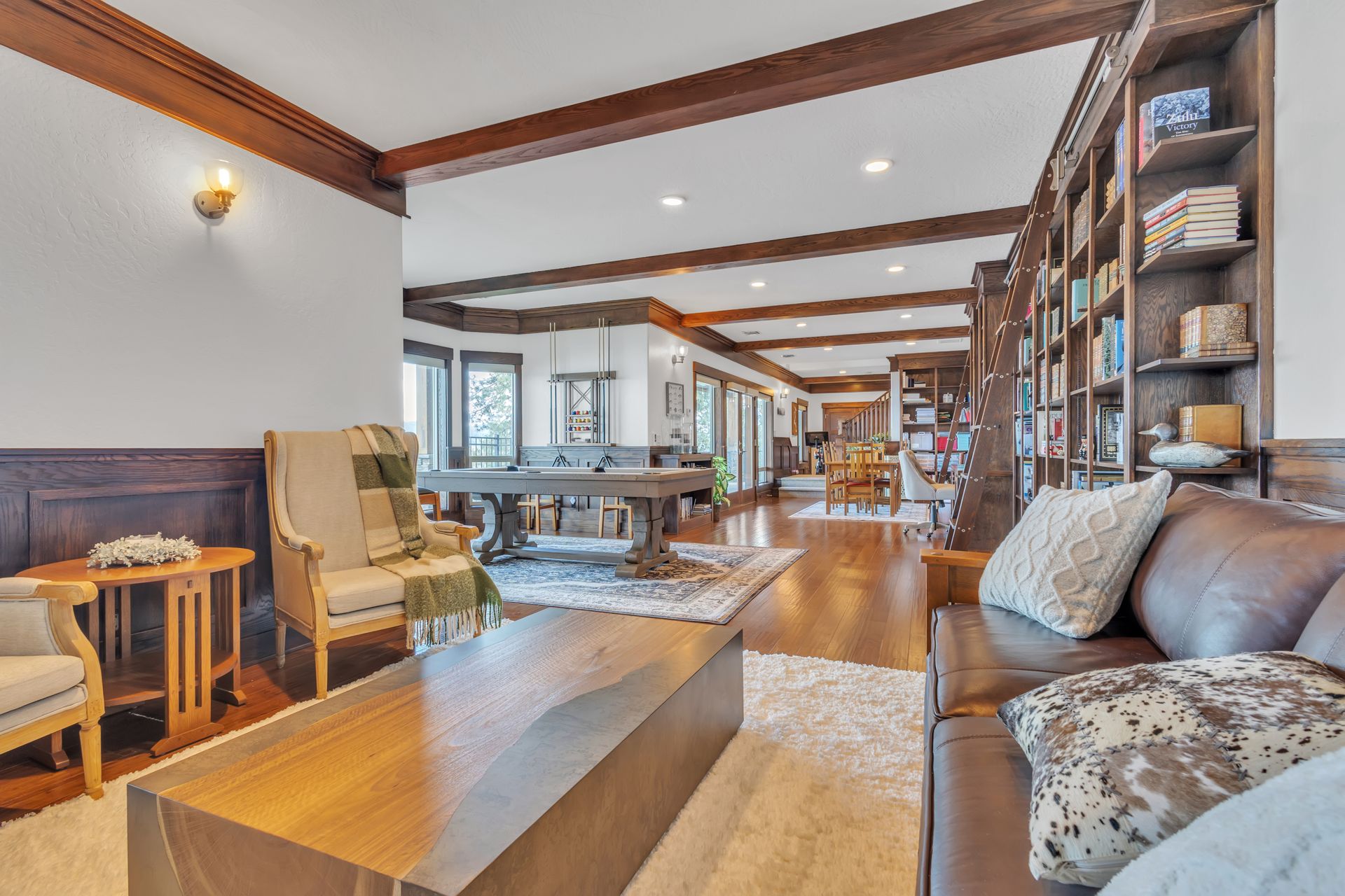 Living room with dark wood trim, bookshelves, and view to dining area.