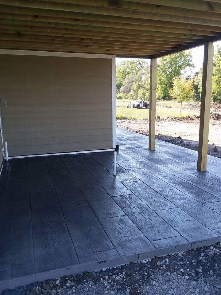A covered patio with a wooden roof is under construction.