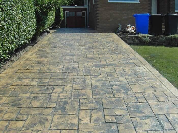 A brick driveway leading to a brick house