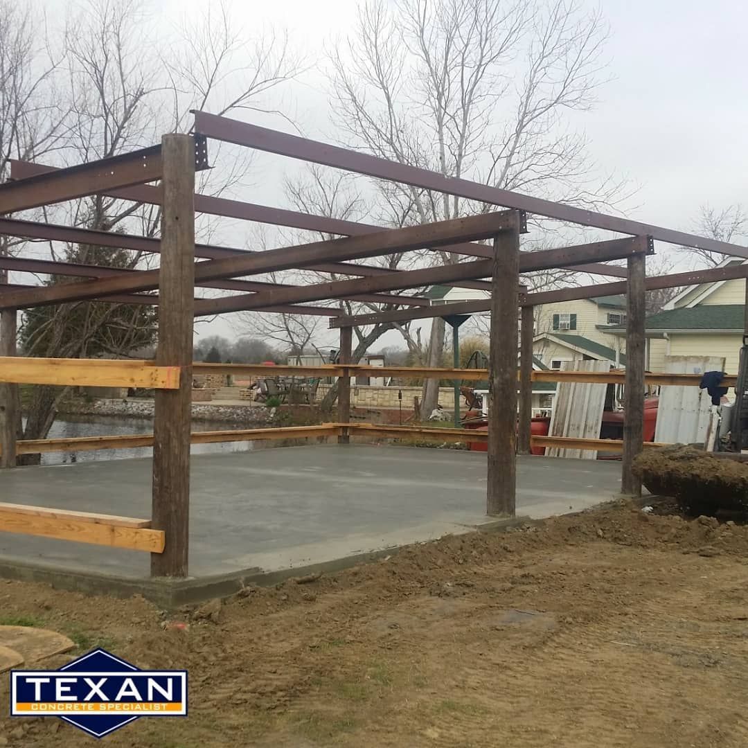 A wooden structure is being built next to a concrete floor.