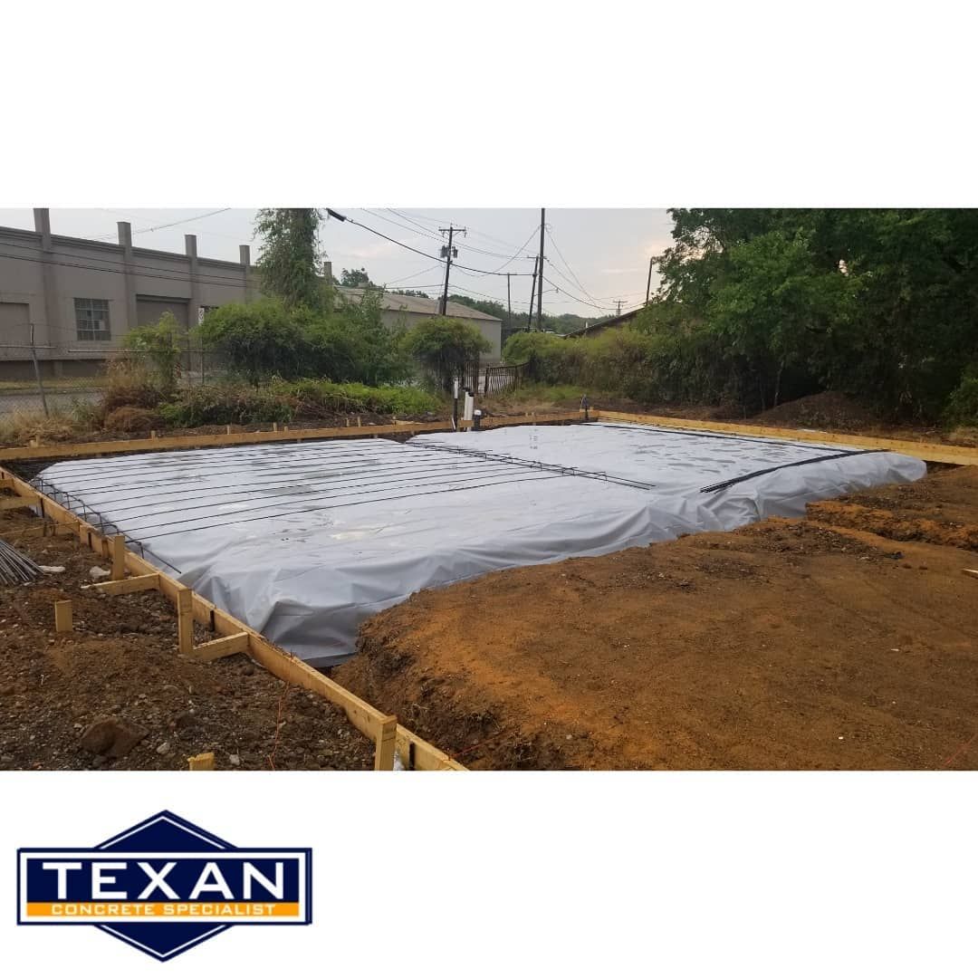 A large pile of dirt is being covered with a tarp.