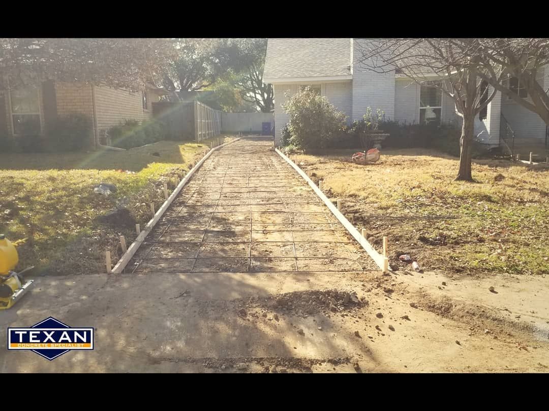 A concrete walkway is being built in front of a house.