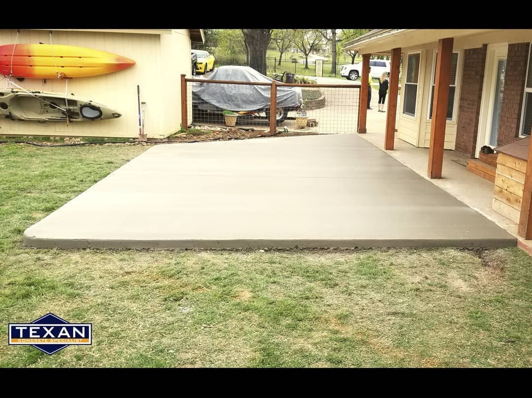 A concrete patio is being built in front of a house.