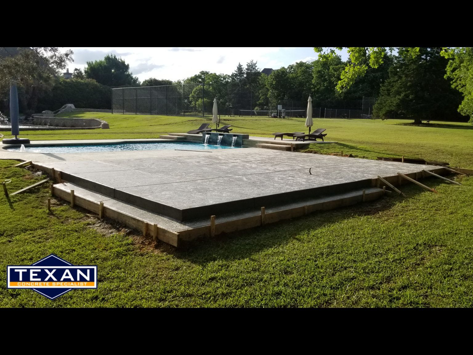 A concrete deck is being built next to a swimming pool