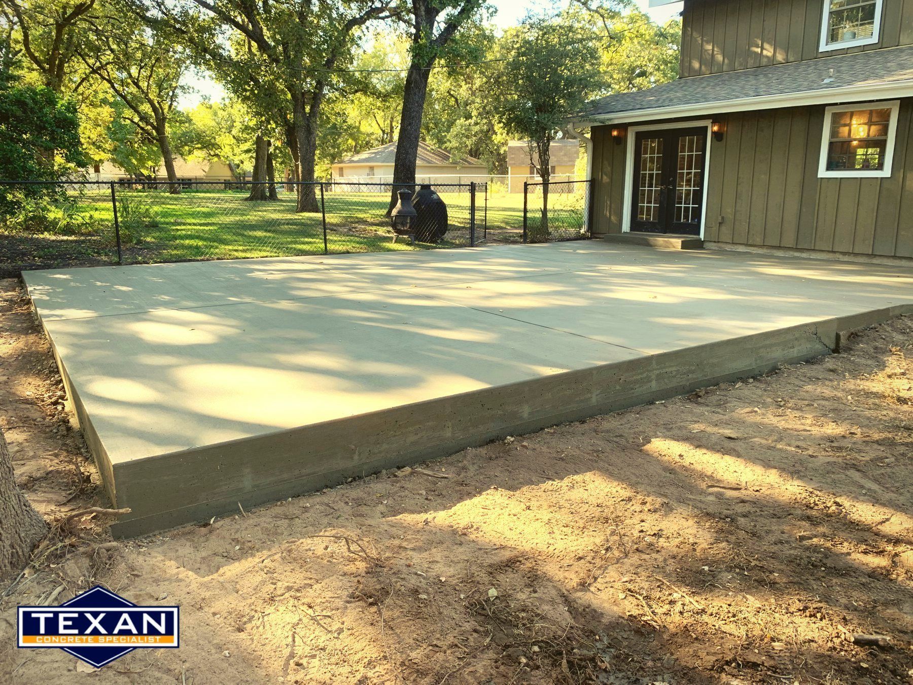 A concrete patio is being built in front of a house.