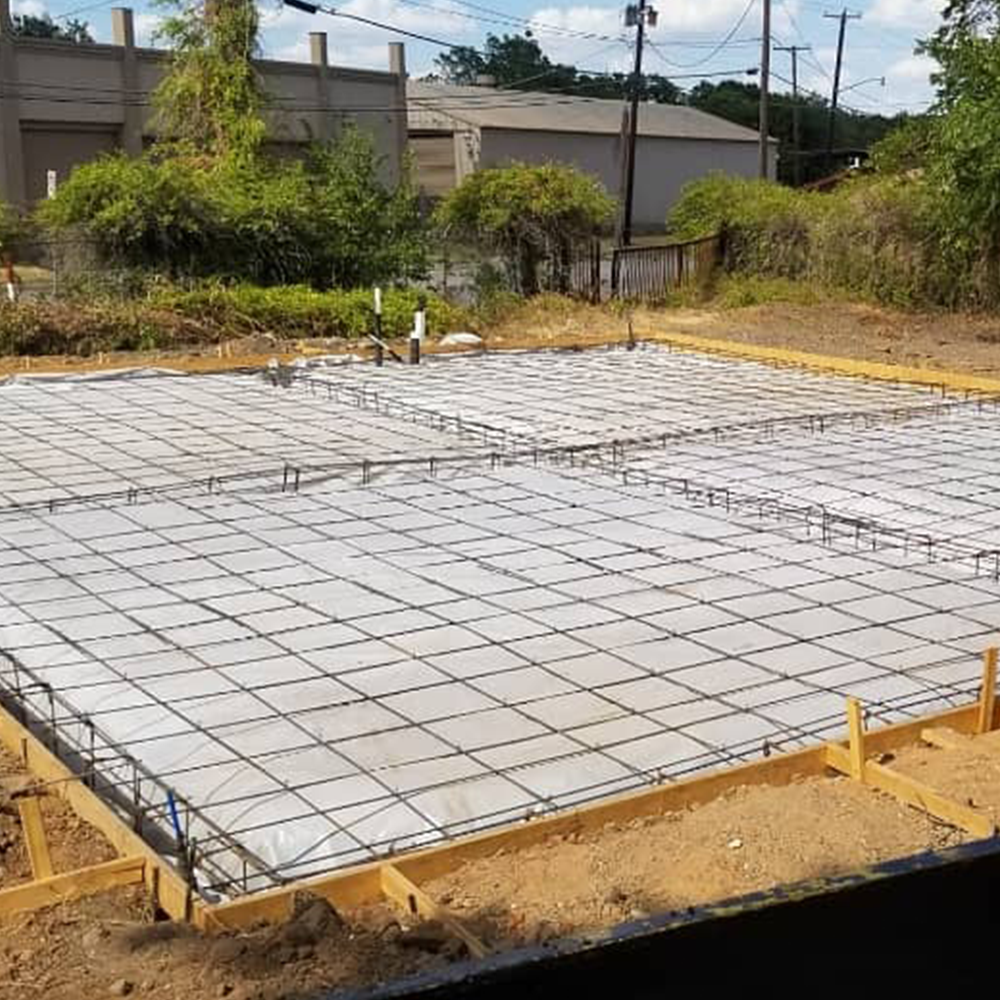 A concrete driveway with a texan logo on it
