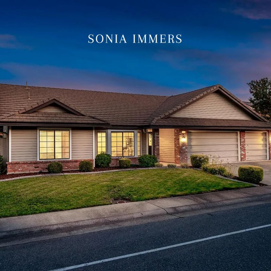 Single-story home with lighting features on, against a night backdrop with Sonia Immers branding.