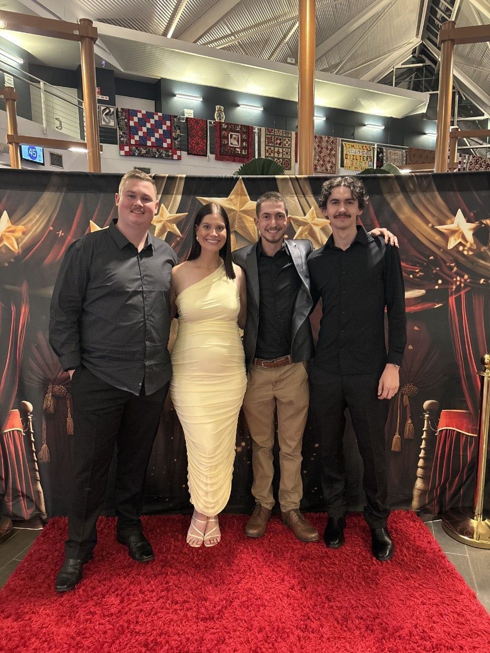 A group of people are posing for a picture on a red carpet — Pacific Plaza Automotive in Port Macquarie, NSW