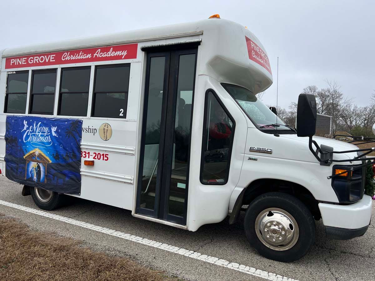 White Pine Grove shuttle bus with red school signage parked on a roadside