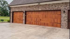 A Large Brick Garage with Three Wooden Garage Doors - Rochester Hills, MI - J & B Doors