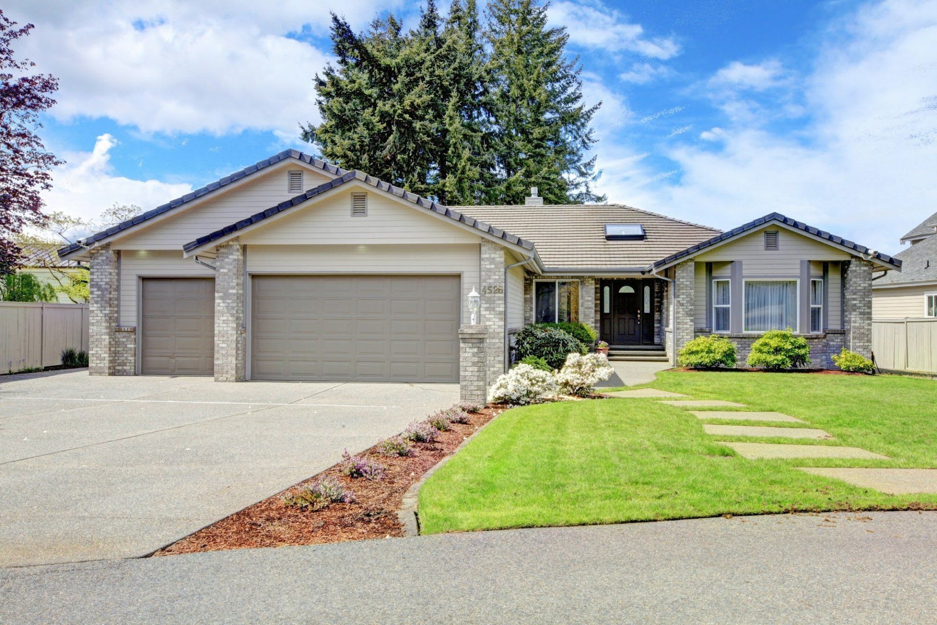 A Large House with Two Garage Doors and A Lush Green Lawn - Rochester Hills, MI - J & B Doors