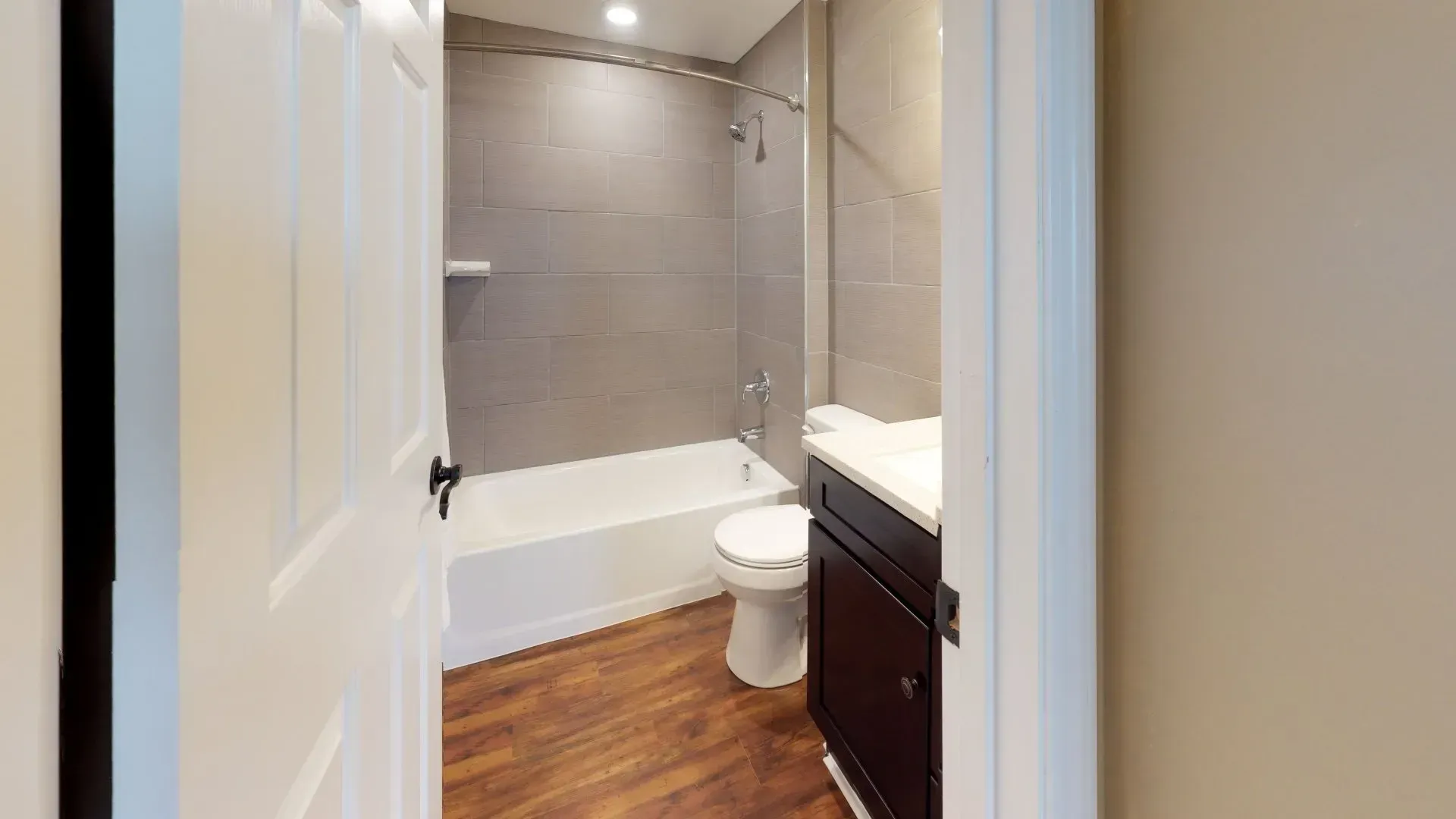 A bathroom with a toilet , sink , bathtub and shower.