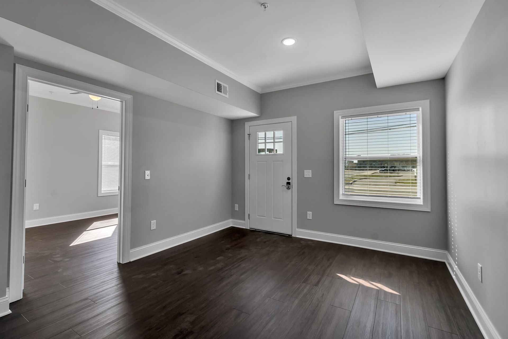 Spacious living room with large window and modern flooring
