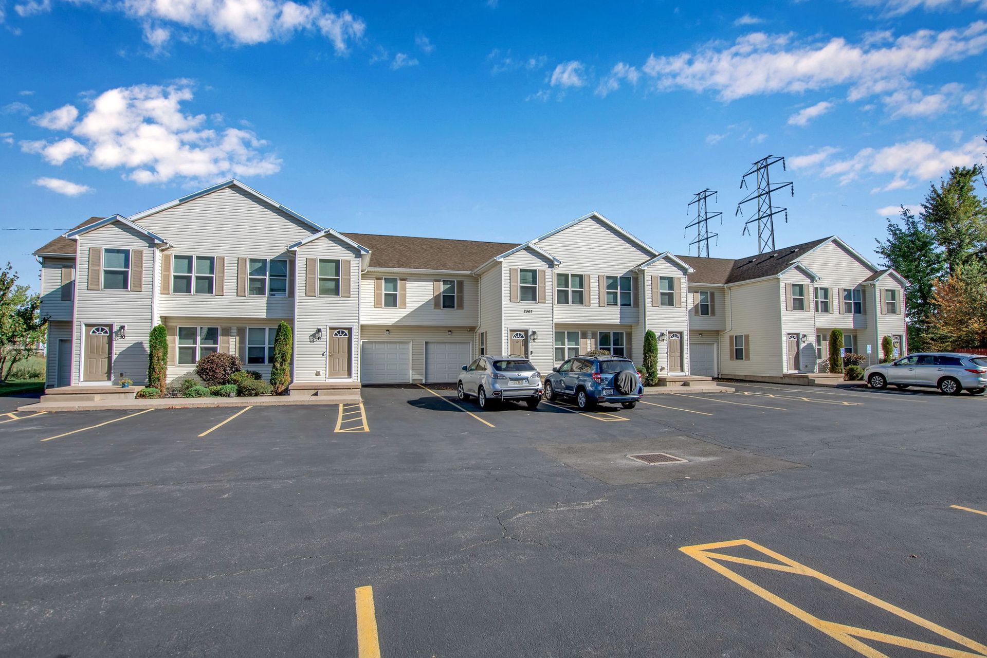 Exterior perspective showing apartment buildings and paved parking areas