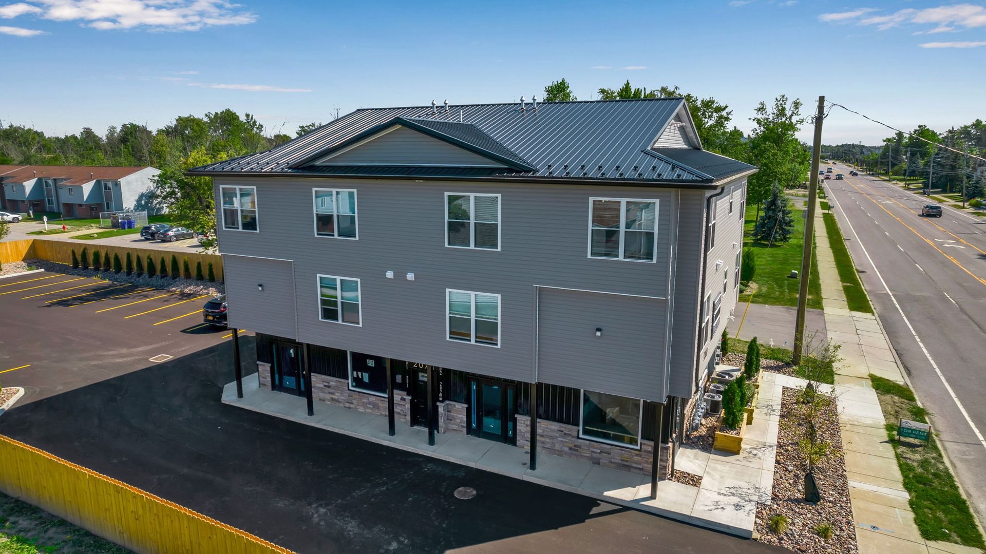 An aerial view of a large apartment building next to a road.