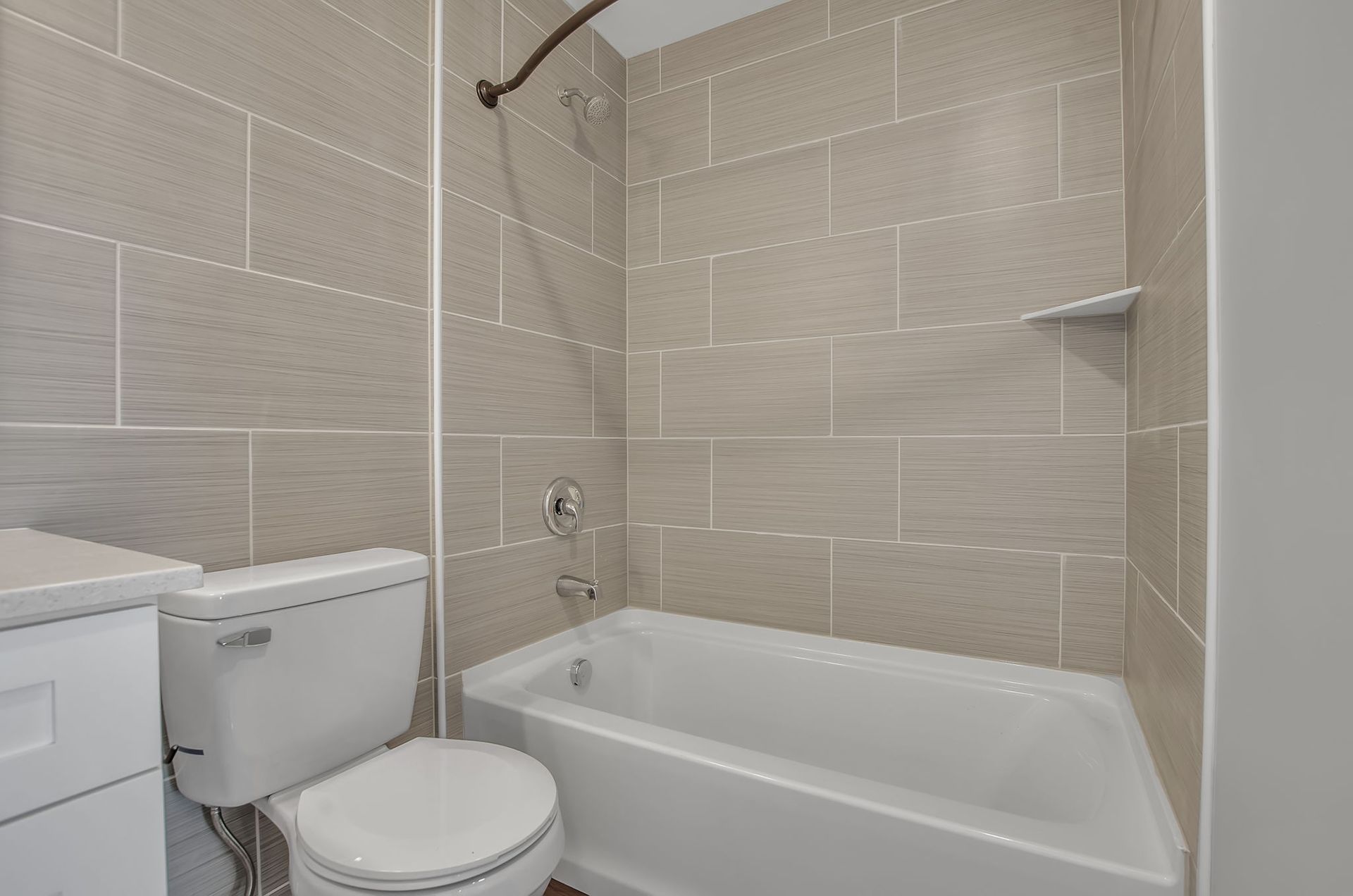 A bathroom with a toilet , tub and shower.