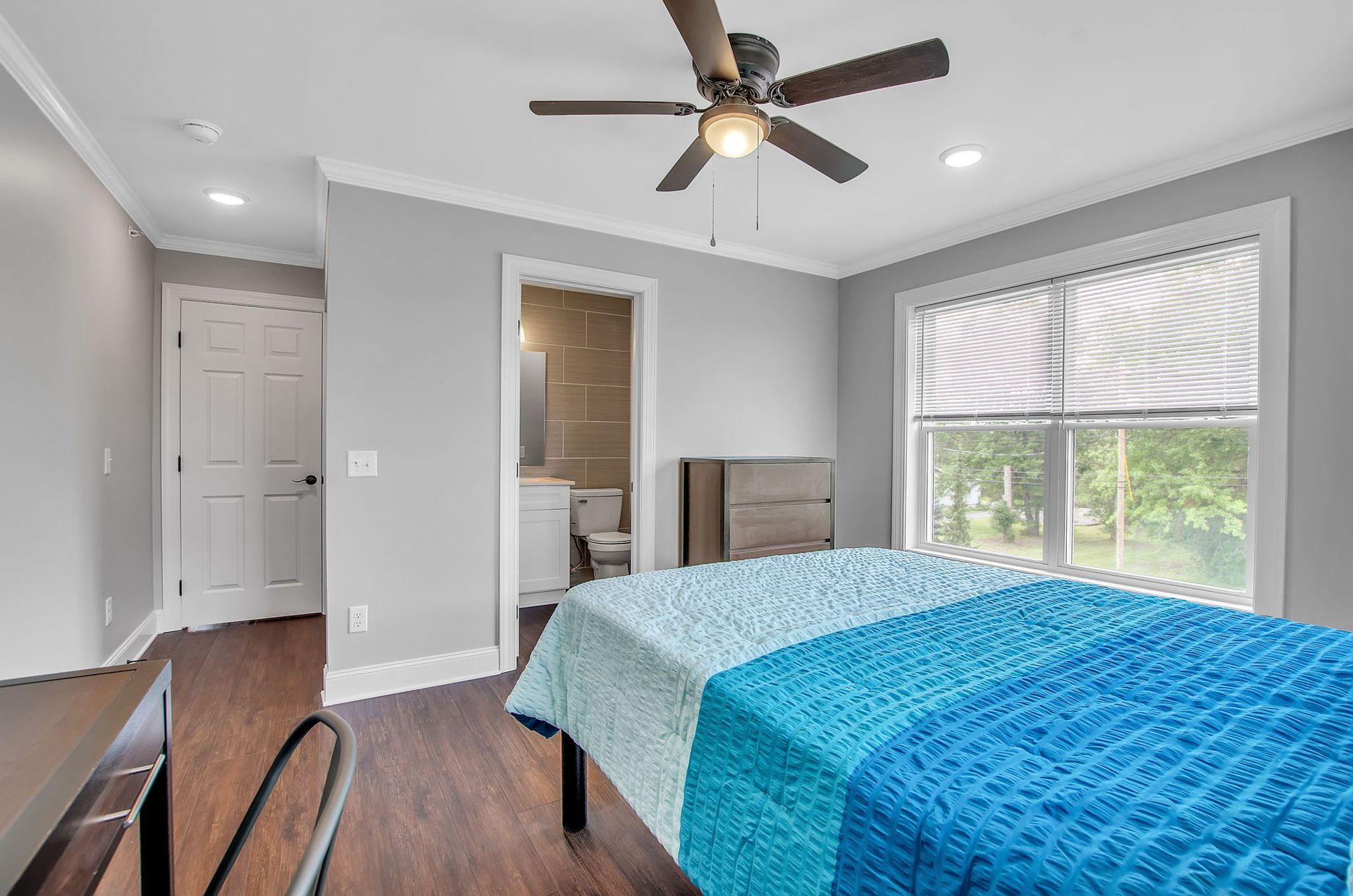 A bedroom with a bed and a ceiling fan.