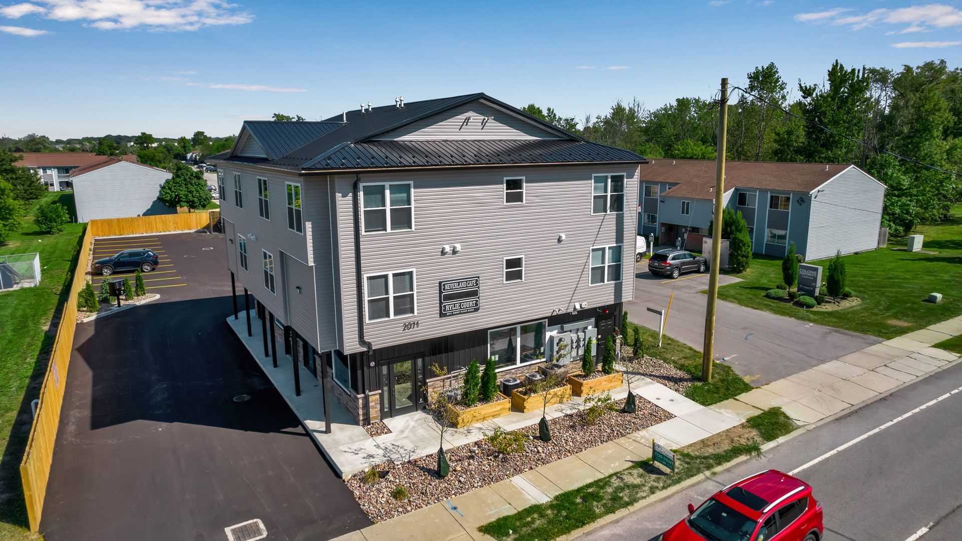Drone image showing apartment buildings arranged around parking areas