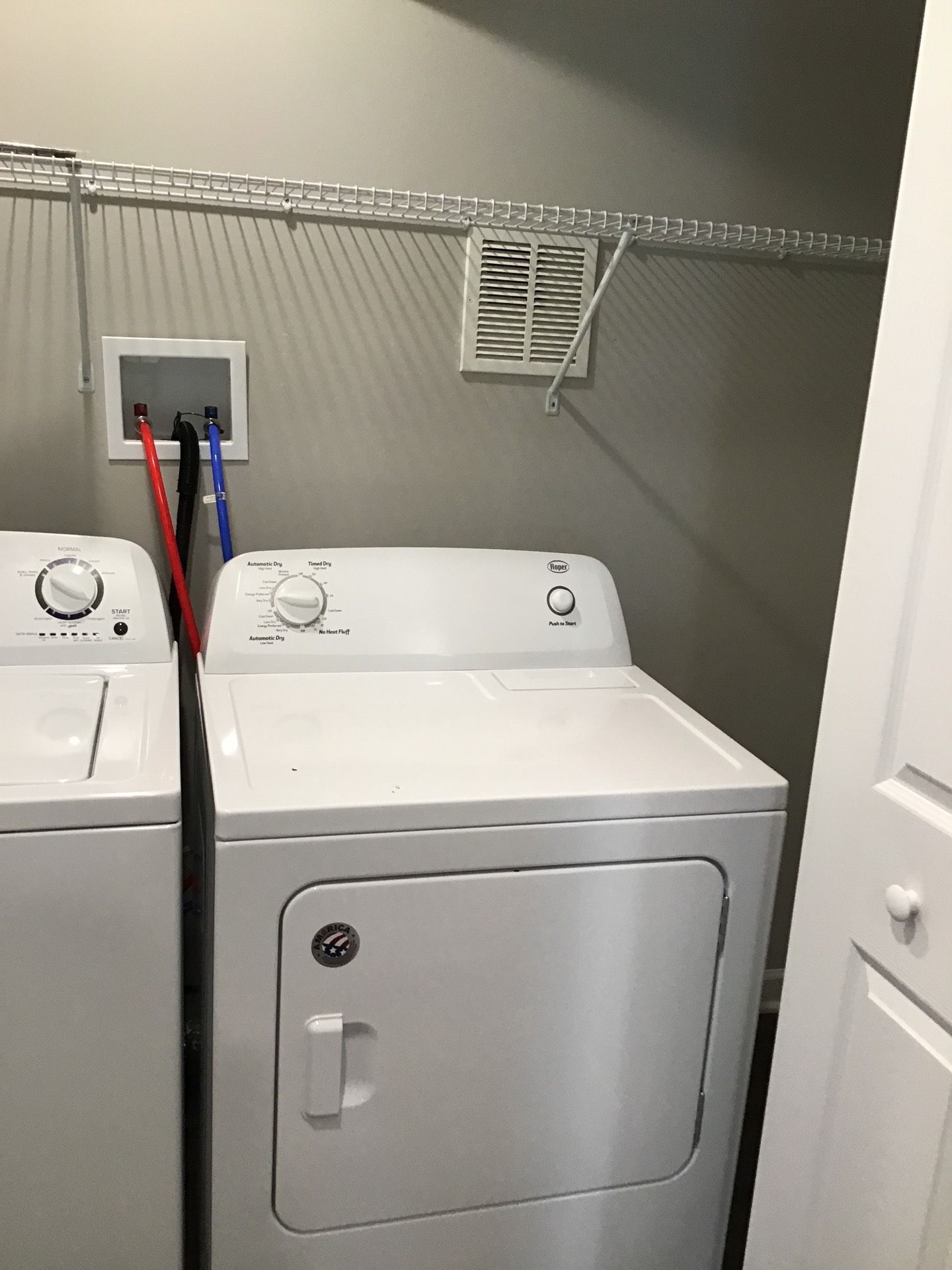 A washer and dryer are sitting next to each other in a laundry room.
