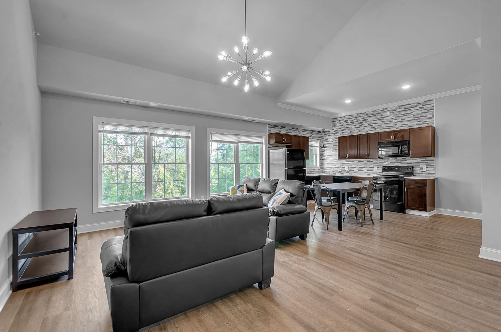 A living room with two couches , a table , and a kitchen.