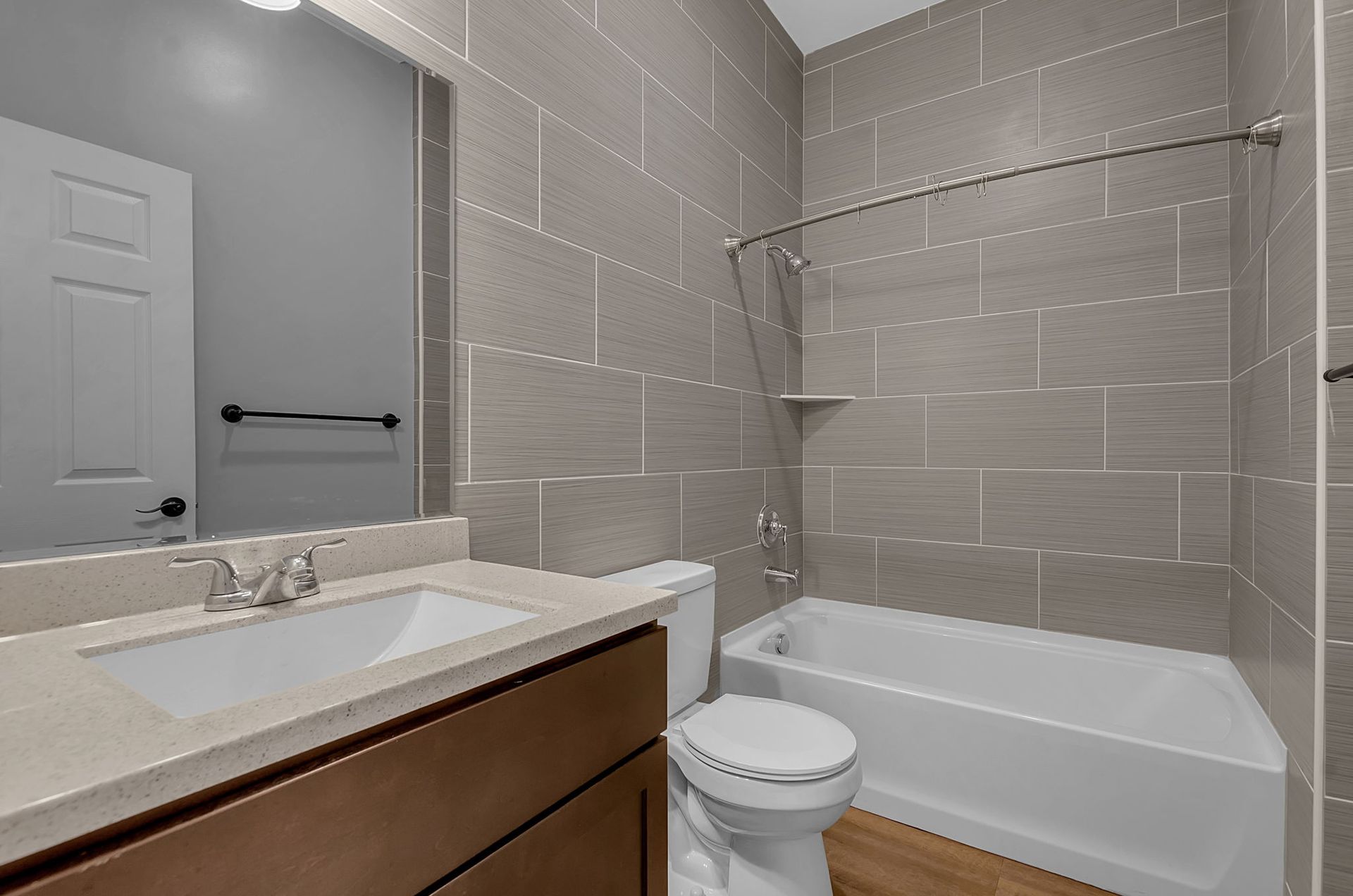 A bathroom with a toilet , sink , bathtub and mirror.