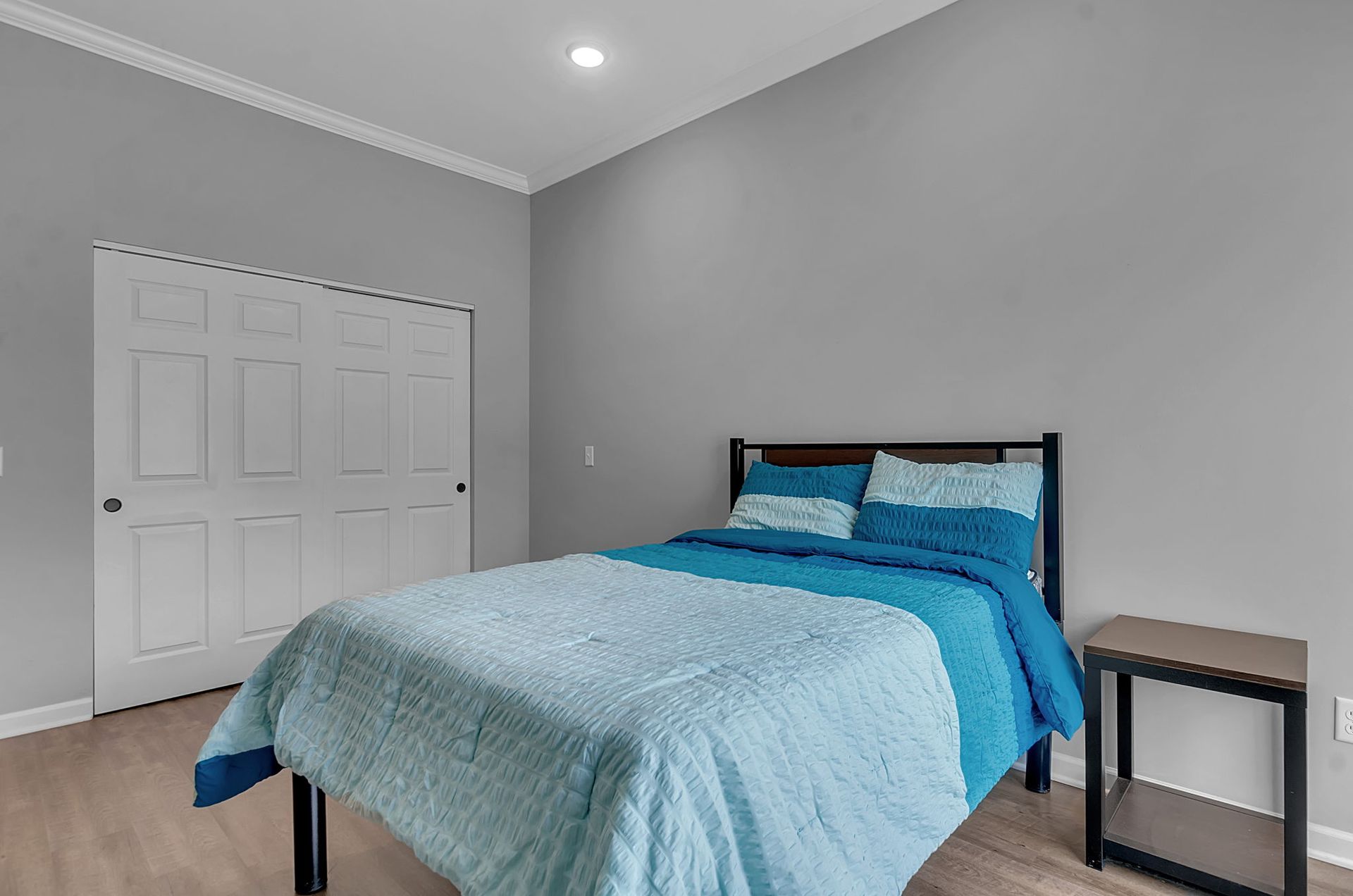 A bedroom with a bed , nightstand , and closet.