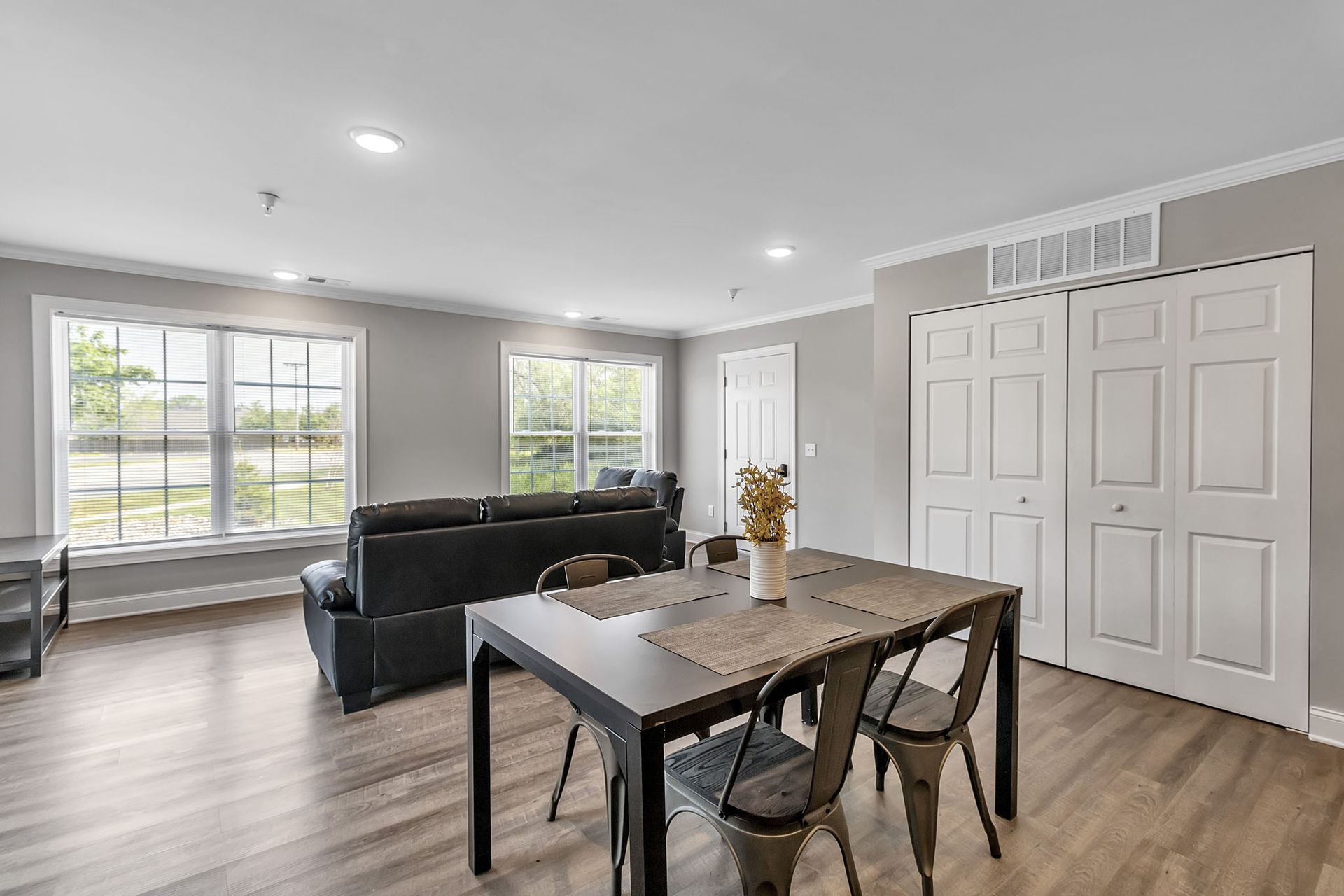 A living room with a table and chairs and a couch.