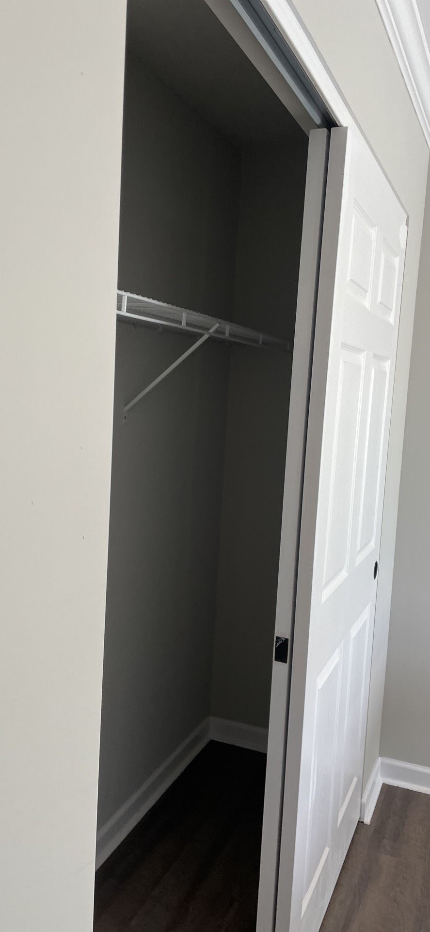 A walk in closet with a sliding door and a shelf.