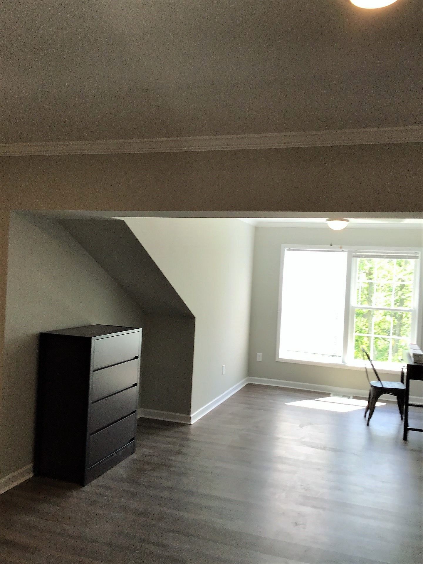 A room with a dresser and a desk in it