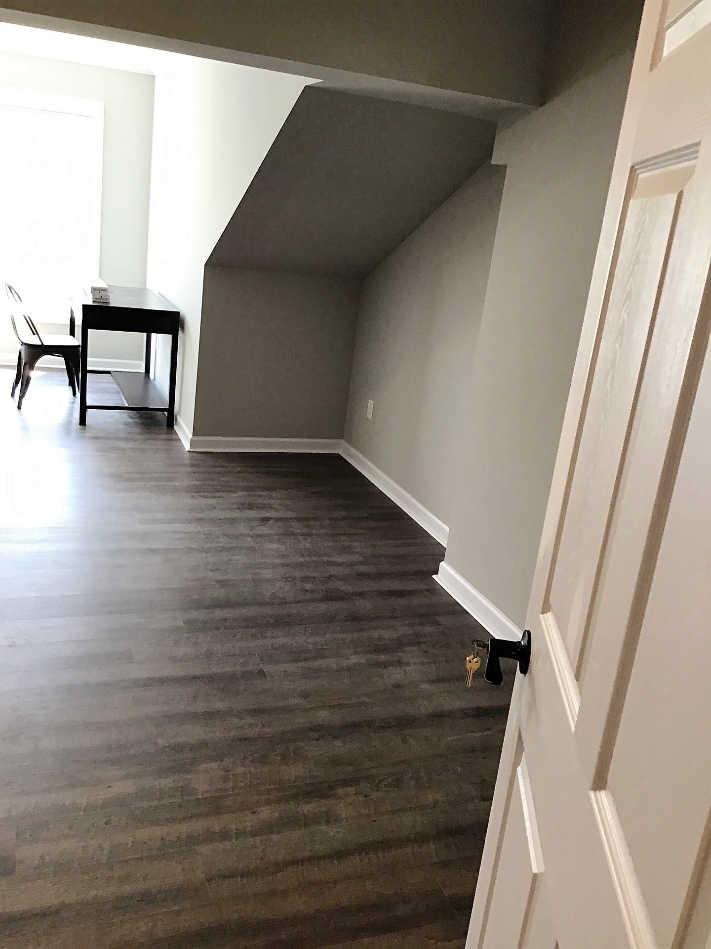 A doorway leading to a room with a desk and chairs.