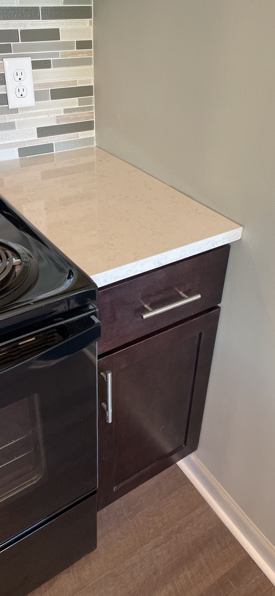 A kitchen with a stove , microwave , and cabinets.