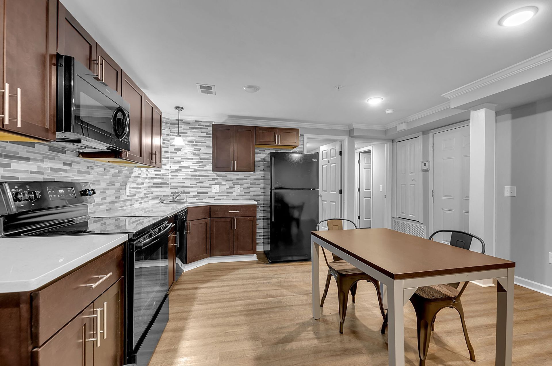 A kitchen with a table and chairs and a refrigerator.