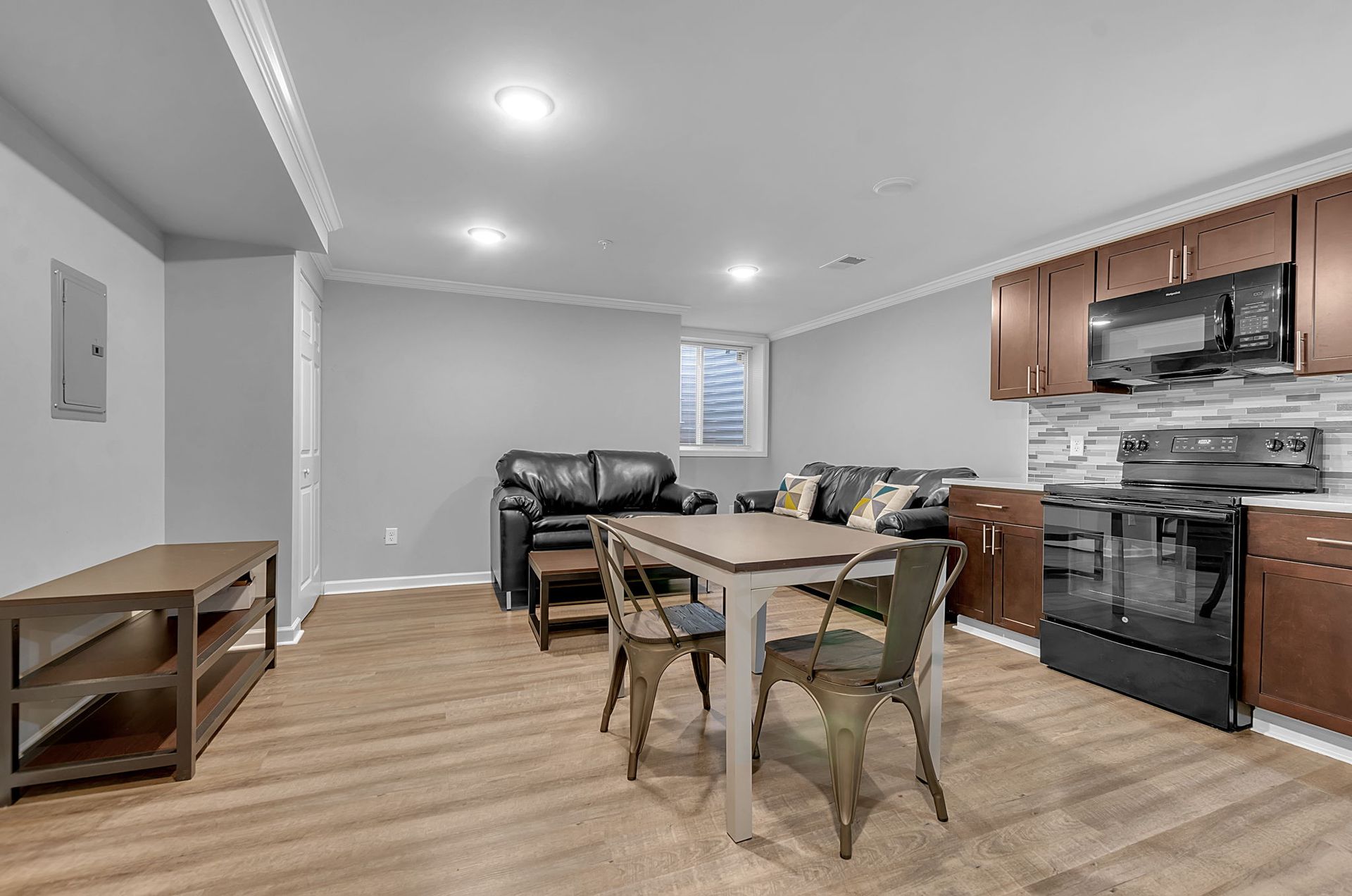 A living room with a table and chairs and a kitchen.
