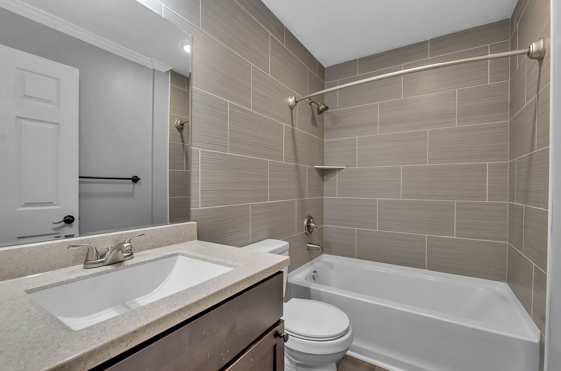 A bathroom with a sink , toilet , bathtub and mirror.