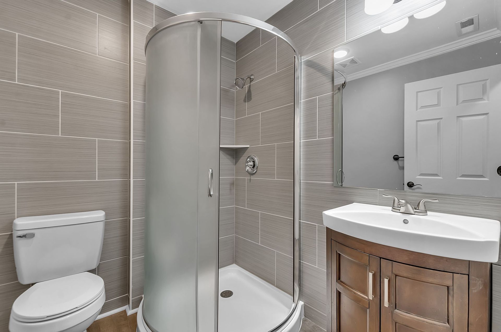 A bathroom with a toilet , sink and shower stall.