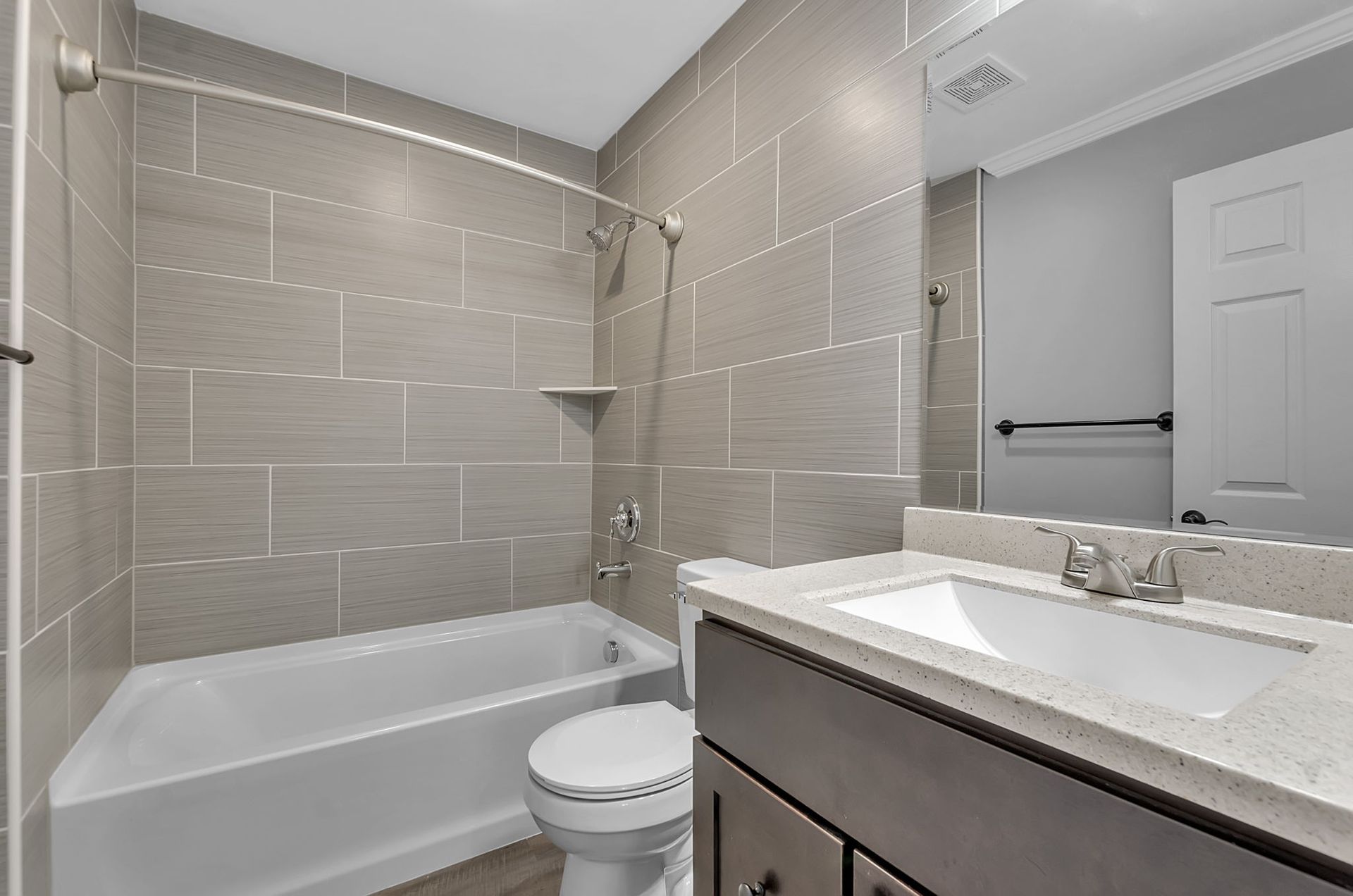 A bathroom with a sink , toilet , bathtub and mirror.