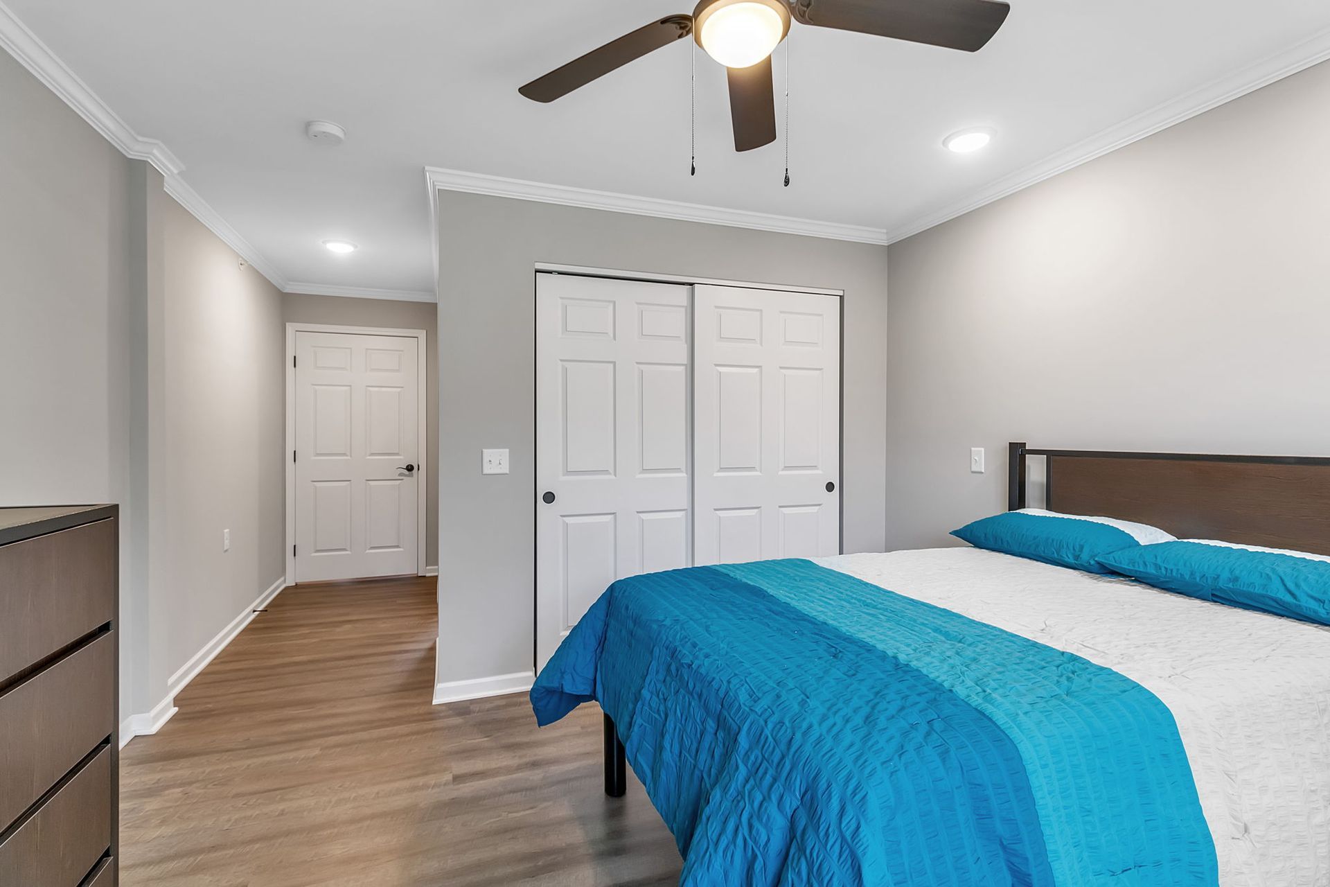 A bedroom with a bed and a ceiling fan.