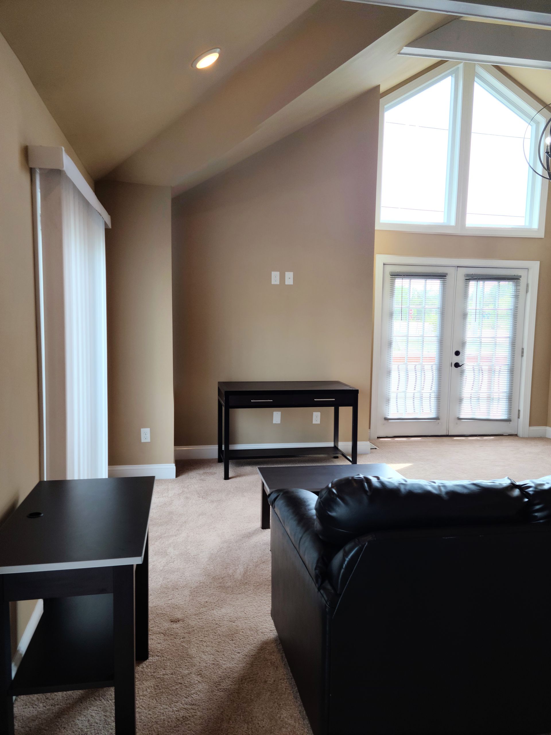 A living room with a black couch and a table