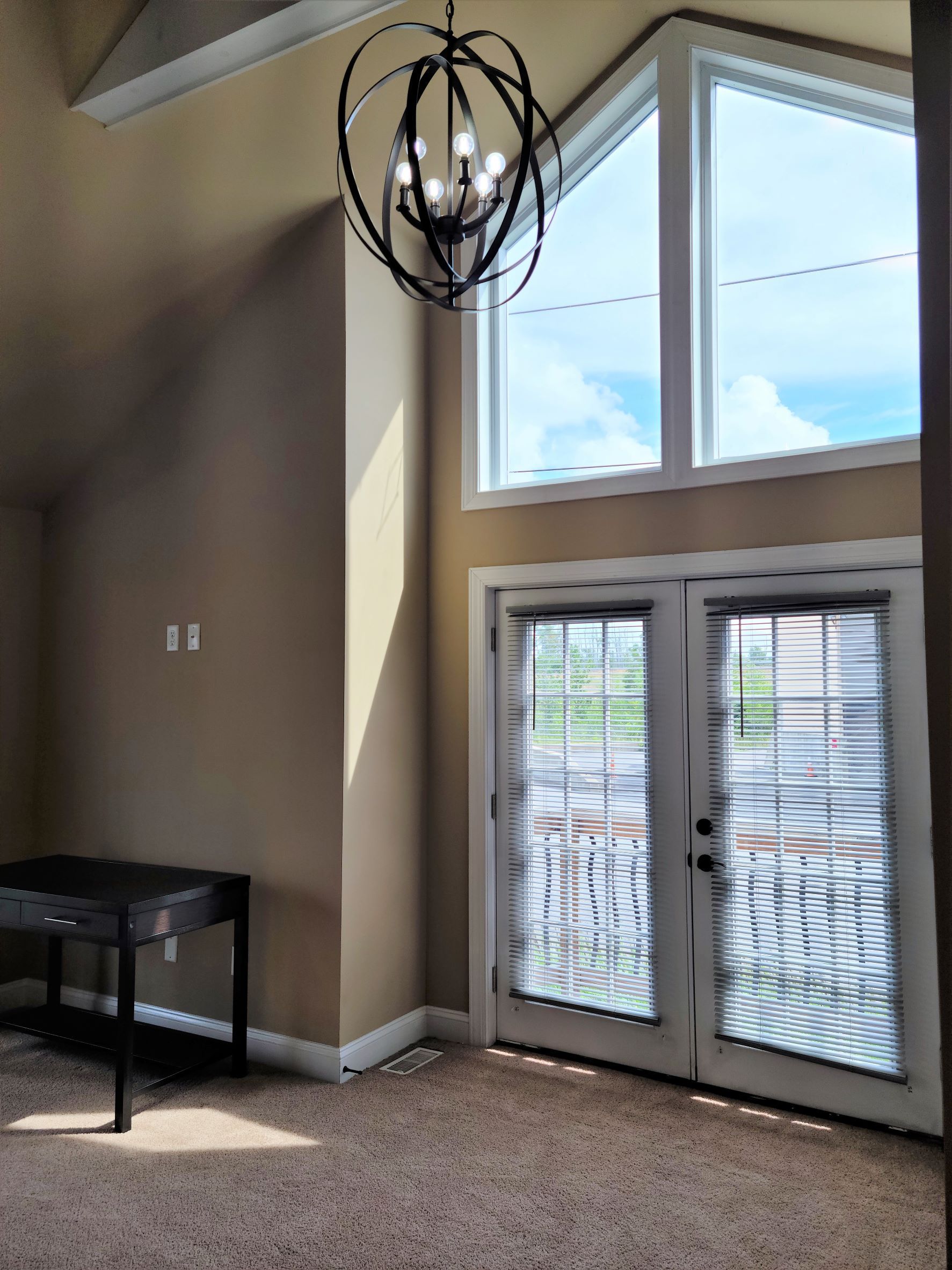 An empty room with a chandelier hanging from the ceiling