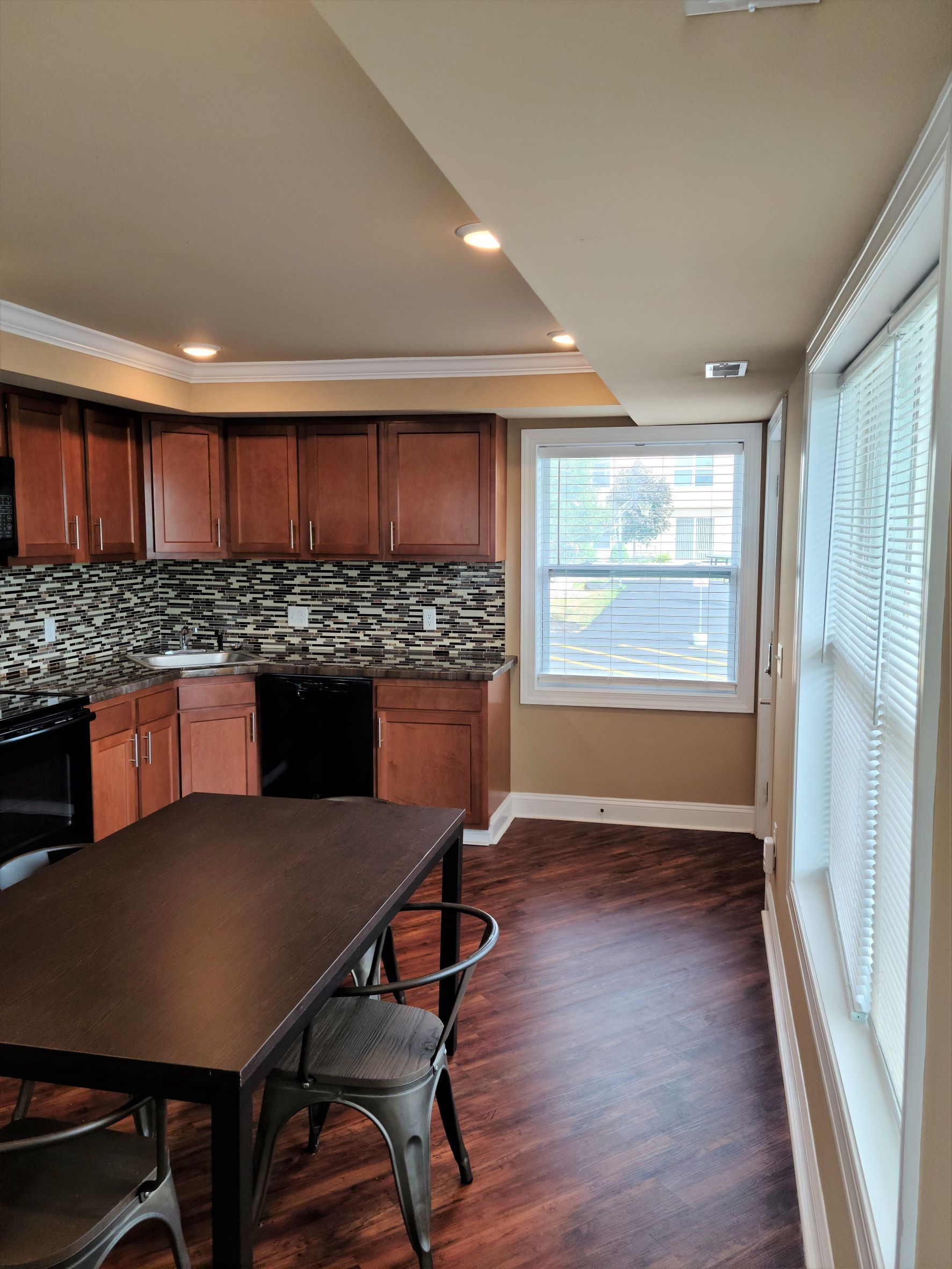 A kitchen with a table and chairs and a large window.