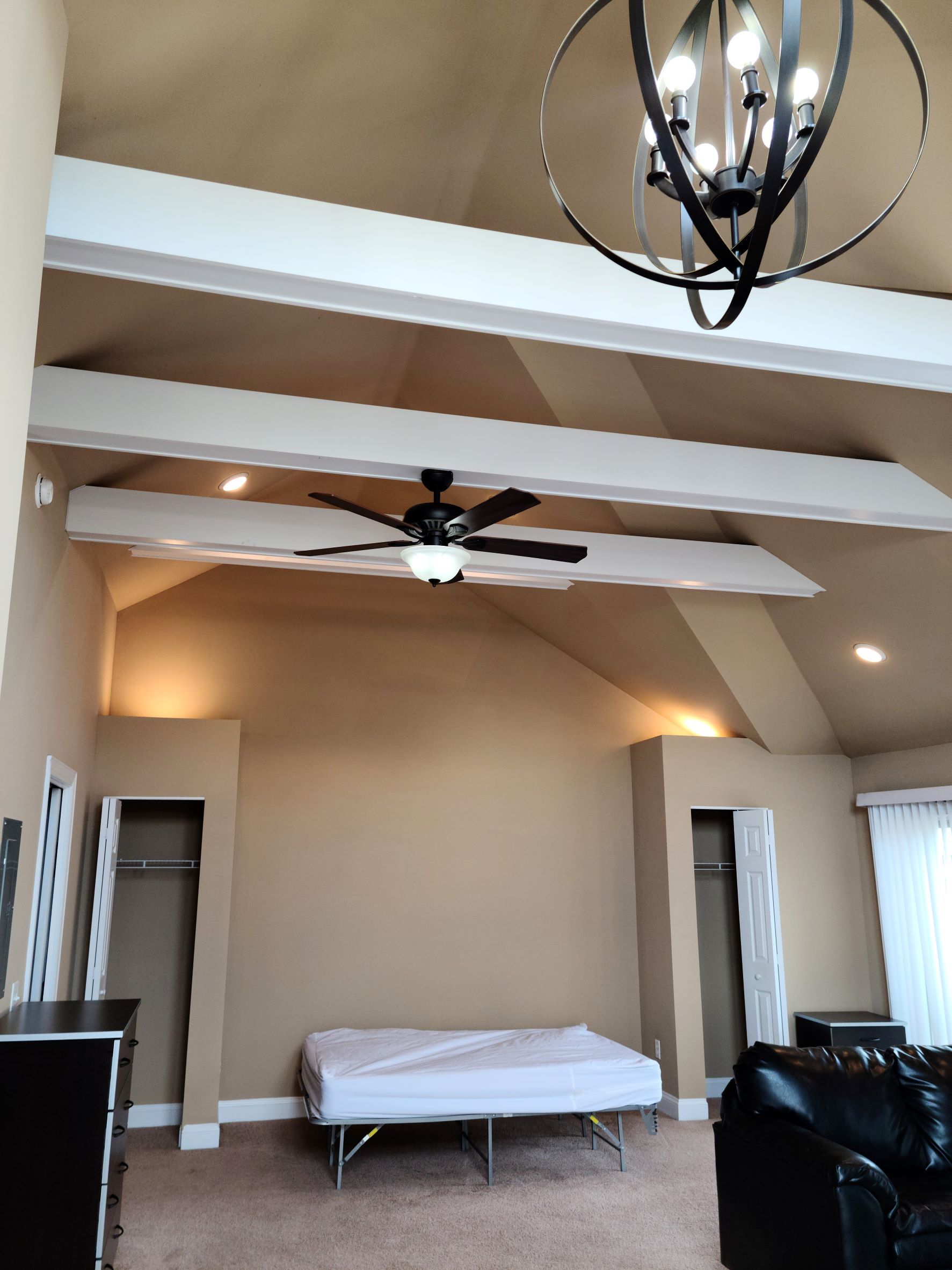 A living room with a ceiling fan and a chandelier