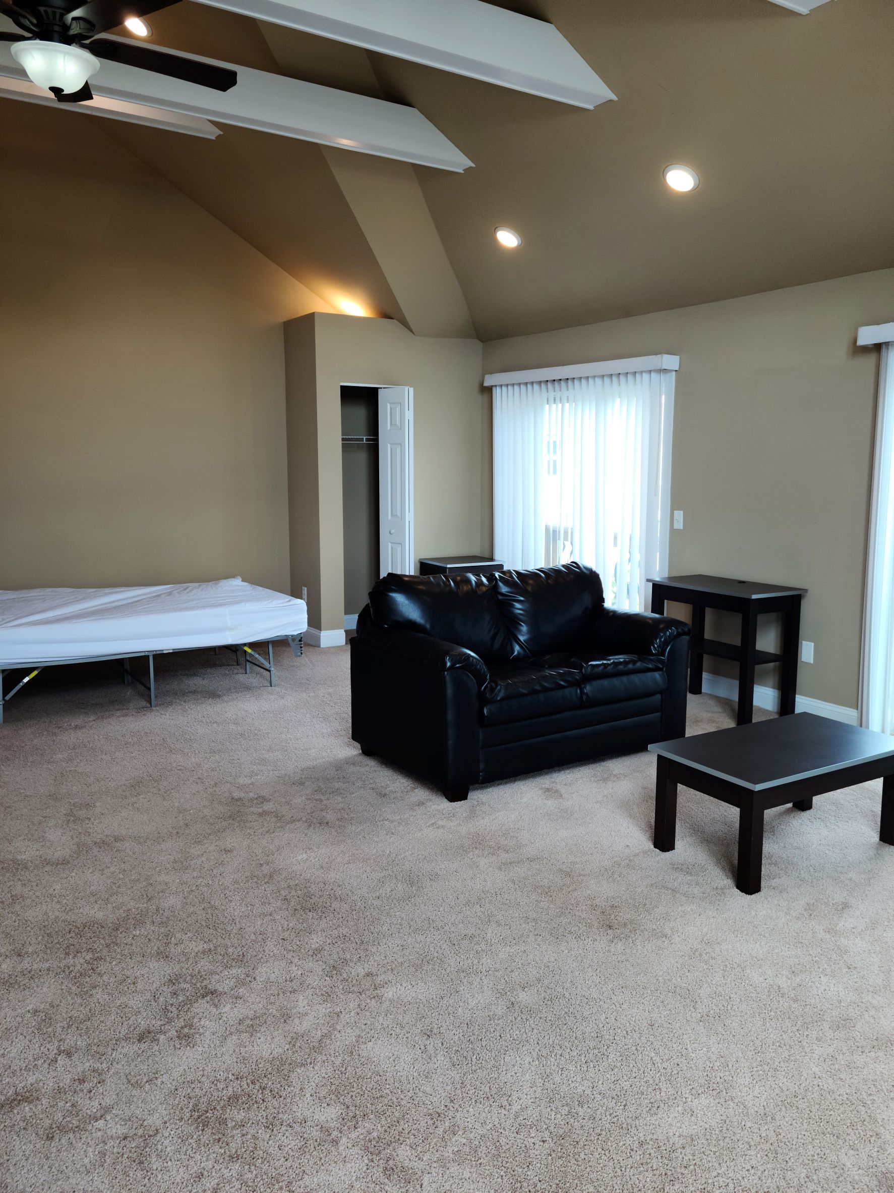 A living room with a black couch and a coffee table