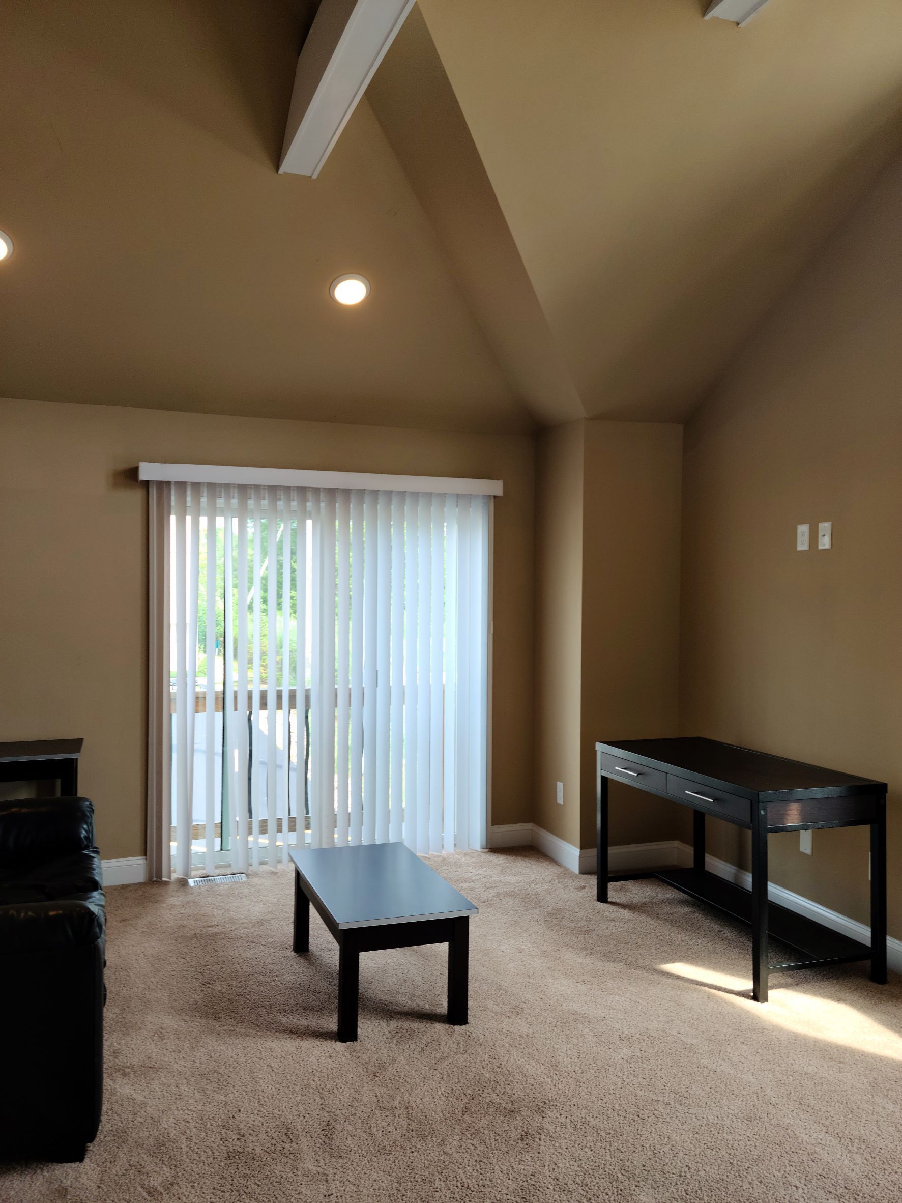A living room with a couch a table and a desk