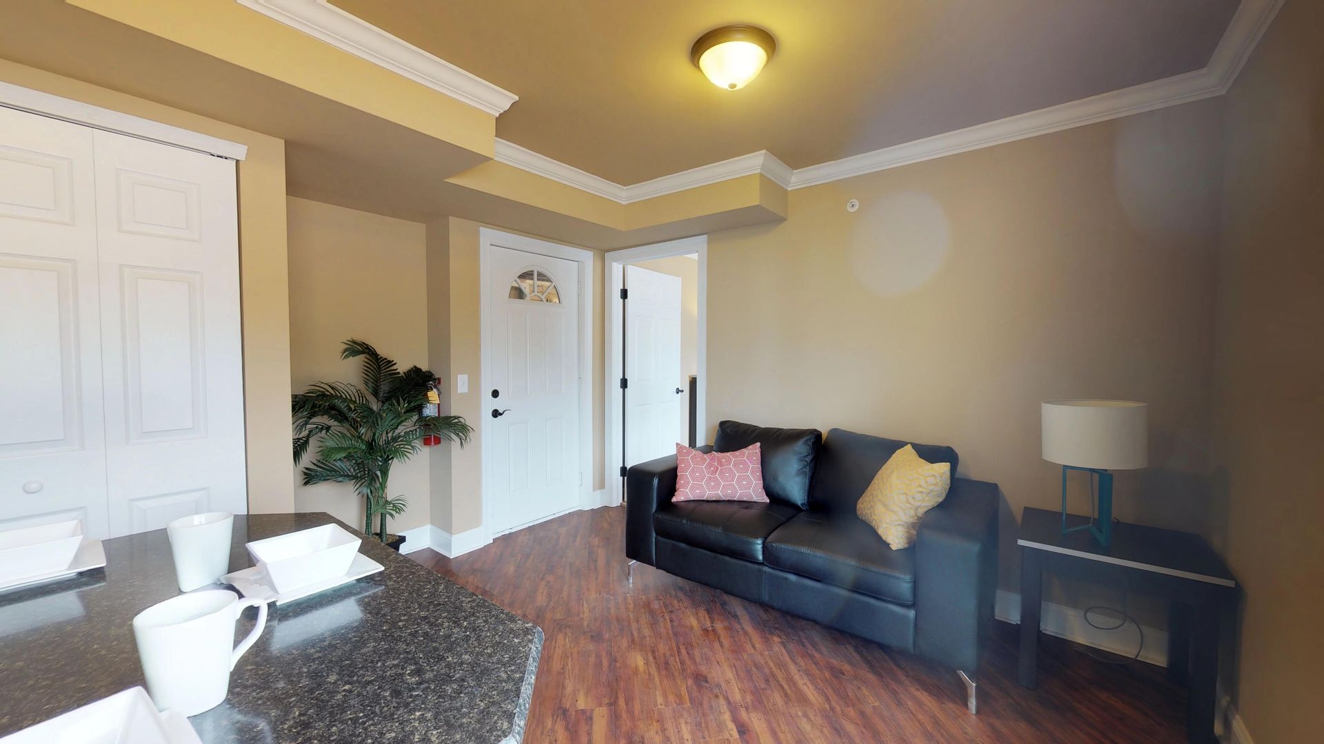 A living room with a couch , table and lamp.