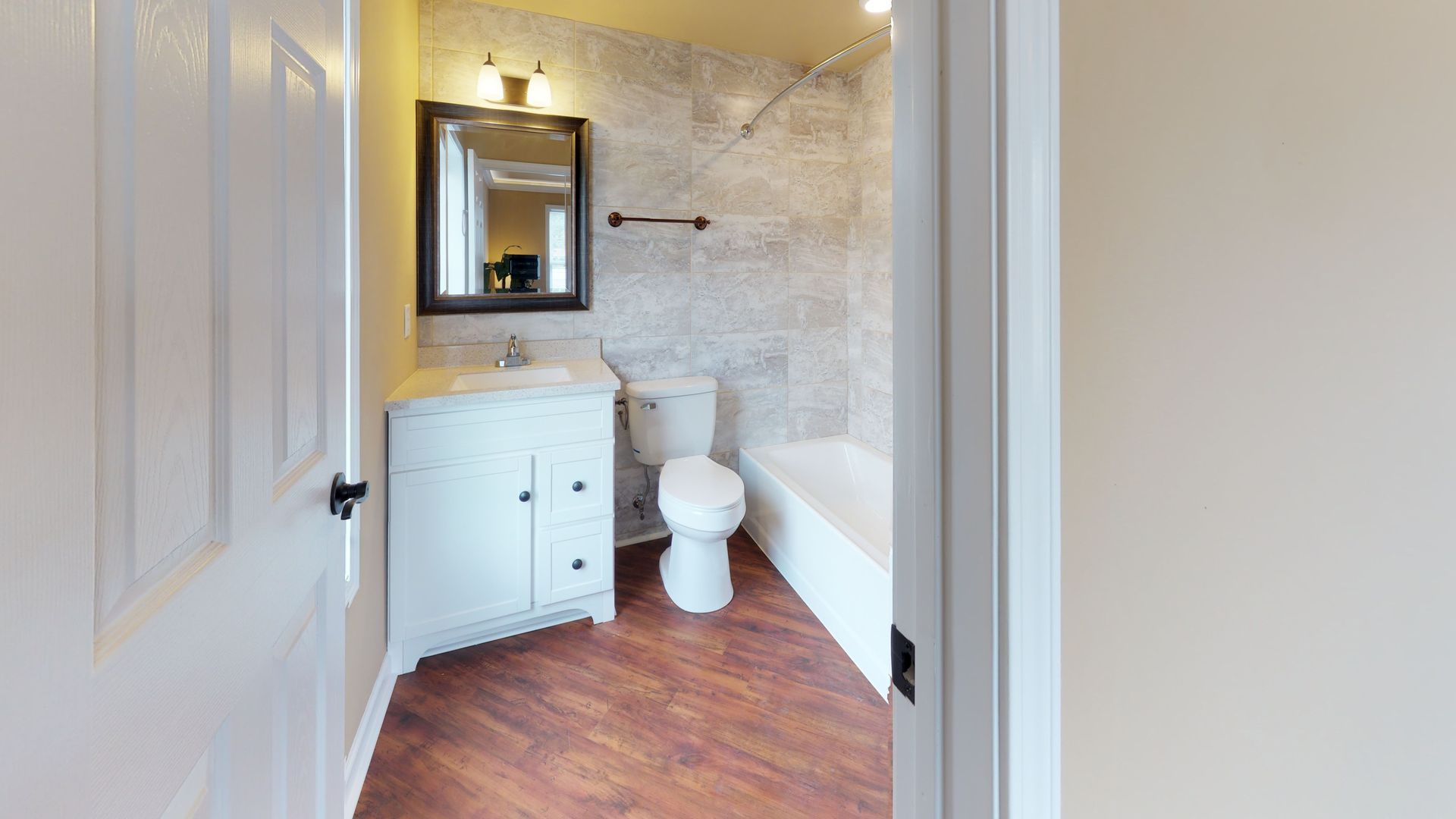 A bathroom with a toilet , sink , and bathtub.