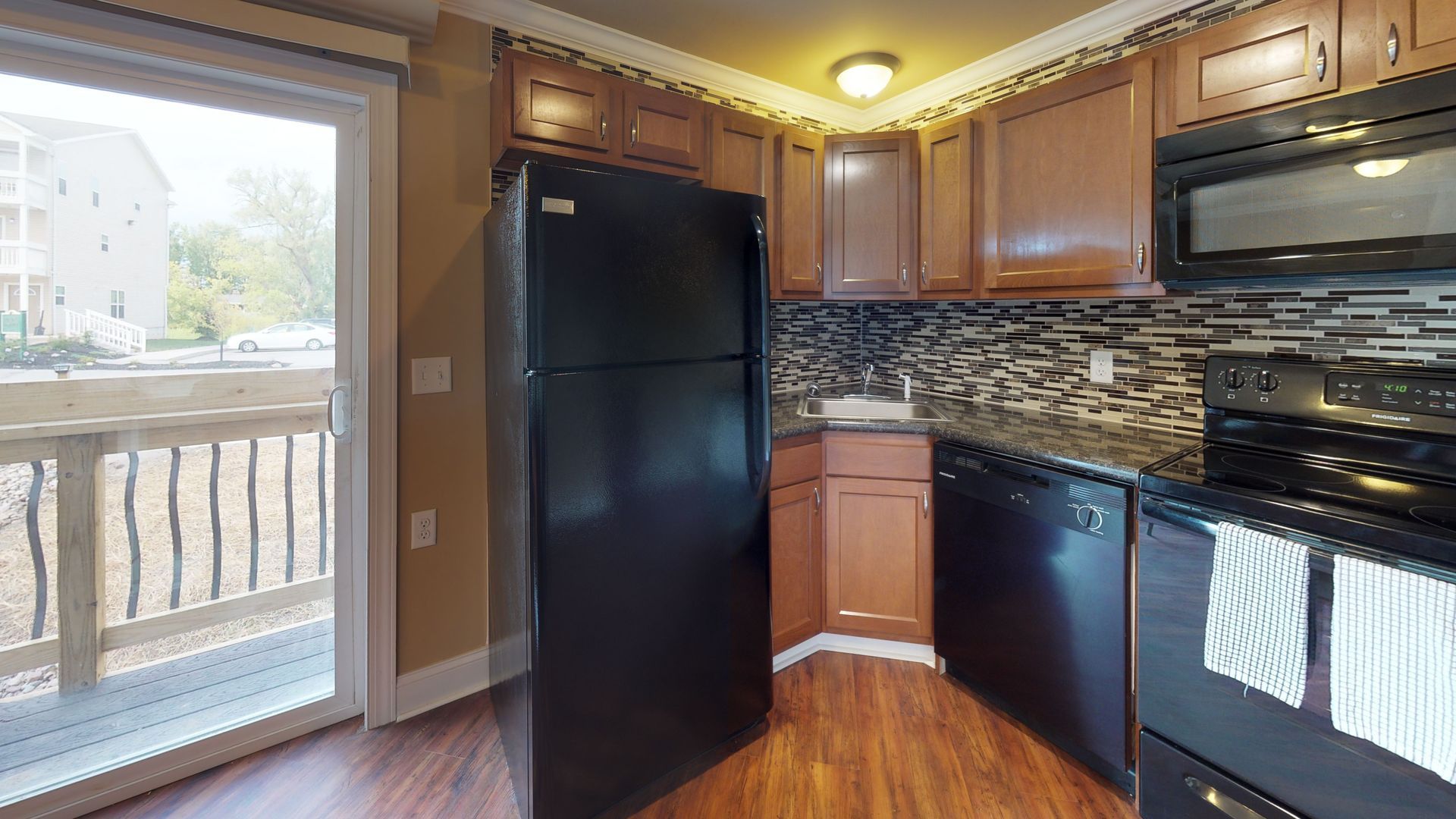 A kitchen with a black refrigerator , stove , dishwasher and microwave.