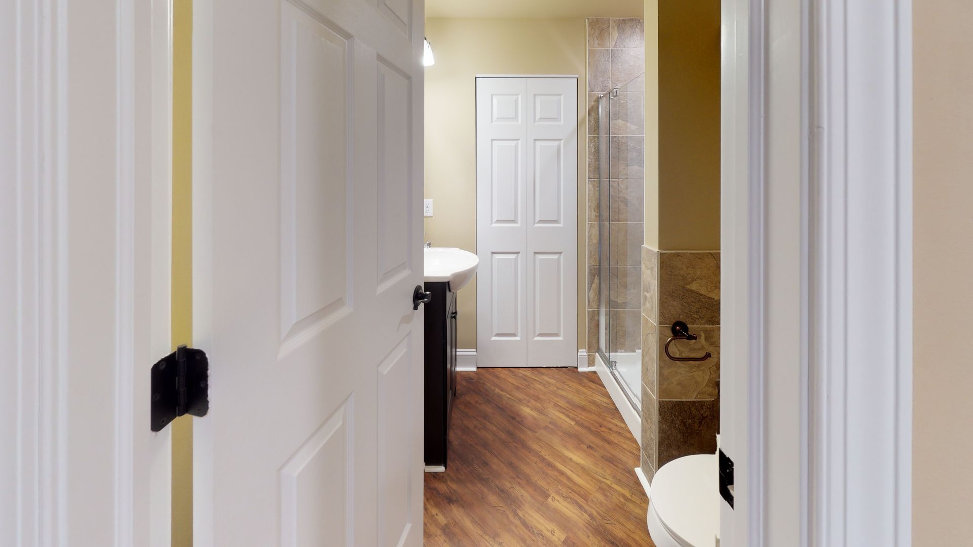 A bathroom with a toilet , sink , and walk in shower.