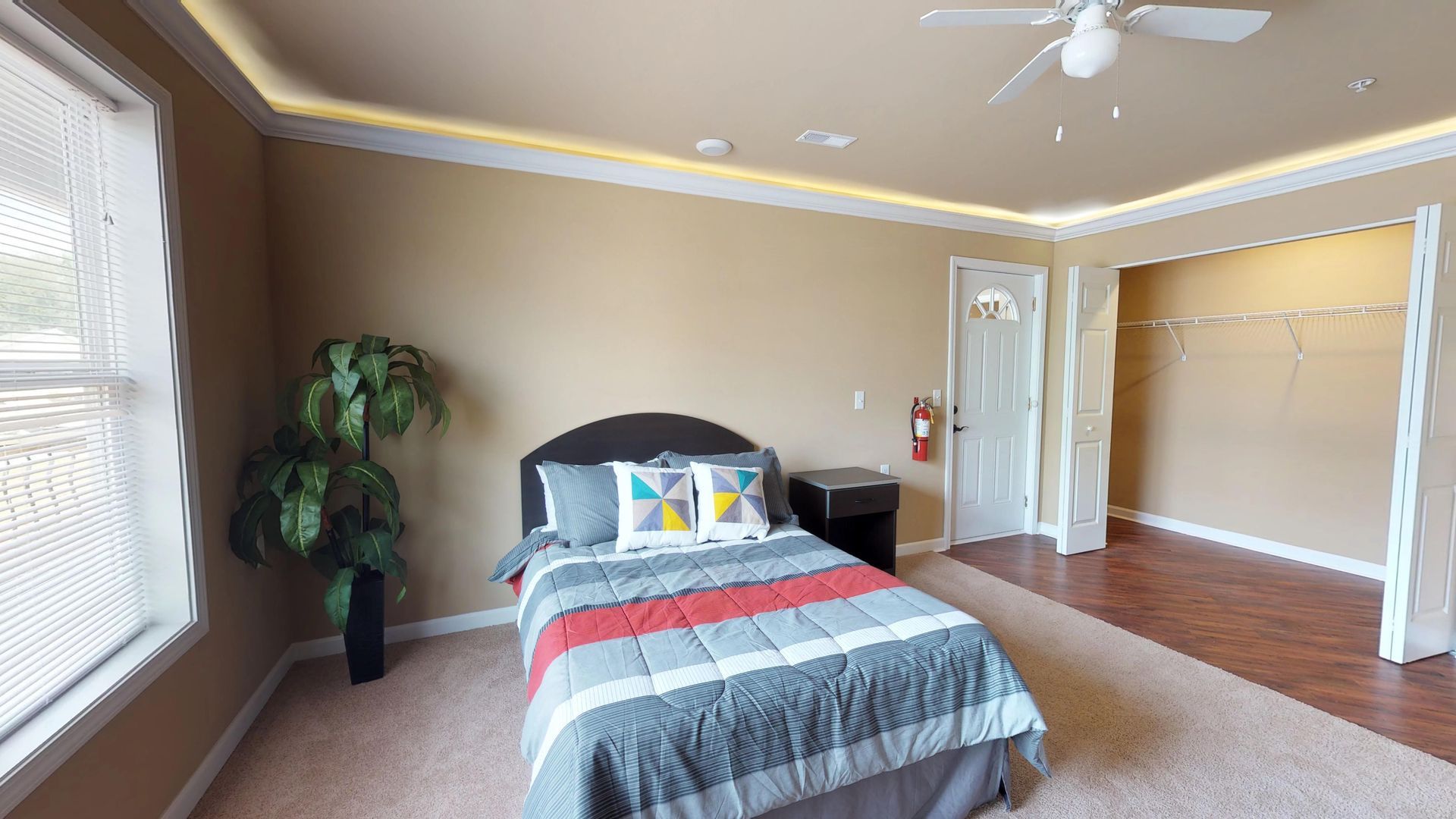 A bedroom with a bed and a ceiling fan.